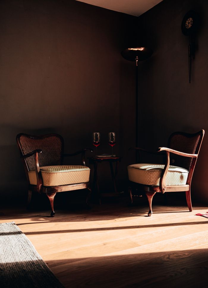 Cozy corner featuring vintage wooden chairs and ambient lighting, perfect for relaxation.